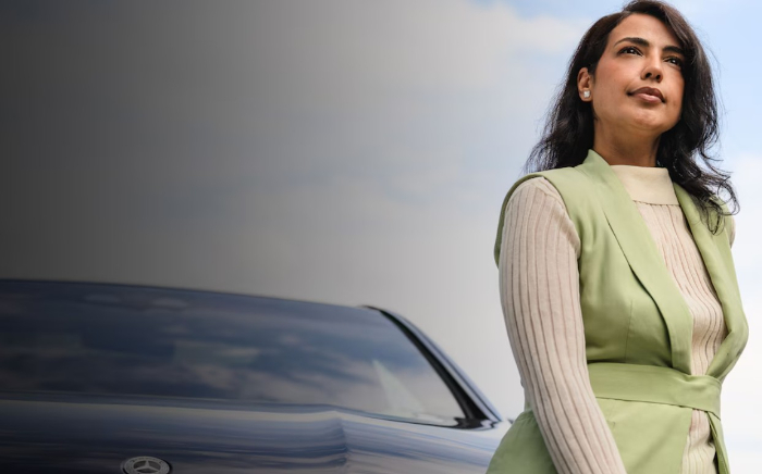 Eine Dame die vor einem Mercedes steht