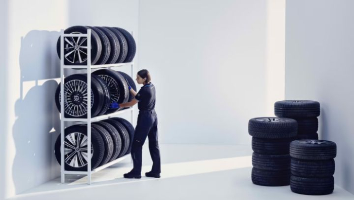 Eine Mechanikerin die R�der einsortiert